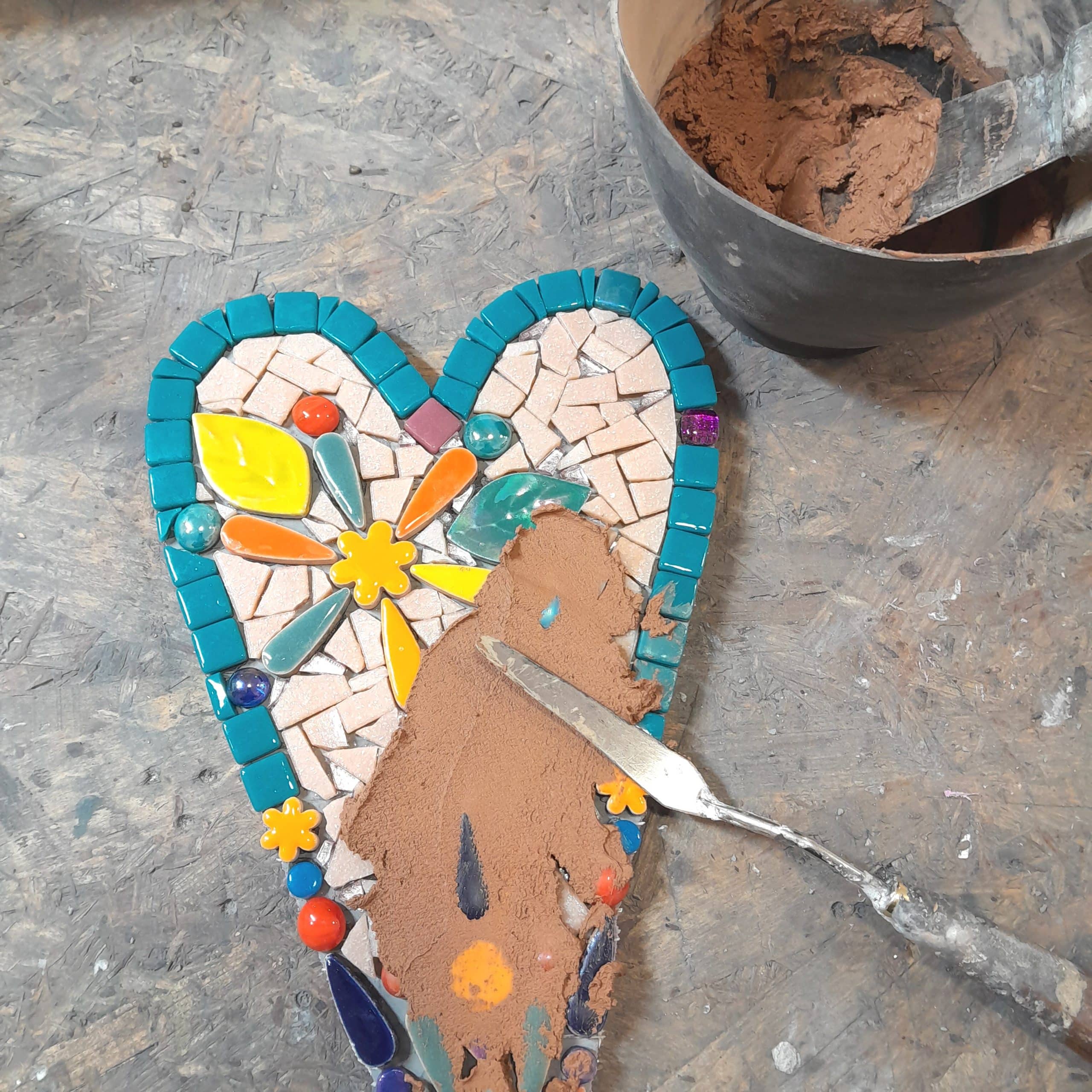 grouting a mosaic heart with Mapei caramel grout