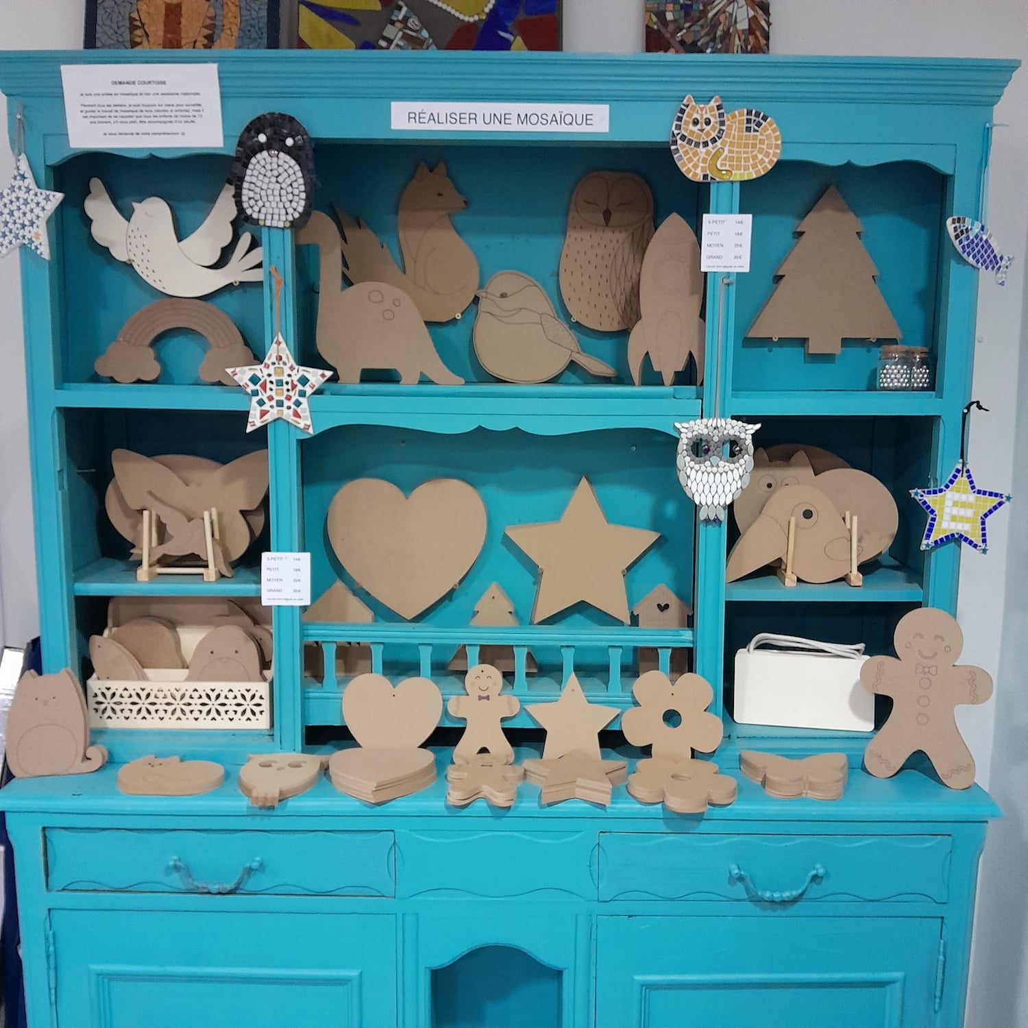 large selection of wooden MDF shapes for mosaic-making organised on a turquoise dresser