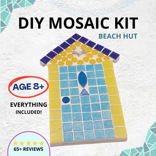 diy mosaic kit image showing beach hut design with yellow walls, a pale blue door and a fish on the front. There is a cut out heart shape at the roof of the beach hut shape